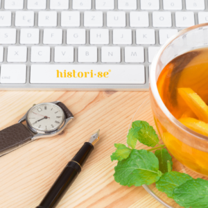 Imagem apresenta relógio, caneta e chá junto ao notebook e ao símbolo de Histori-se.
