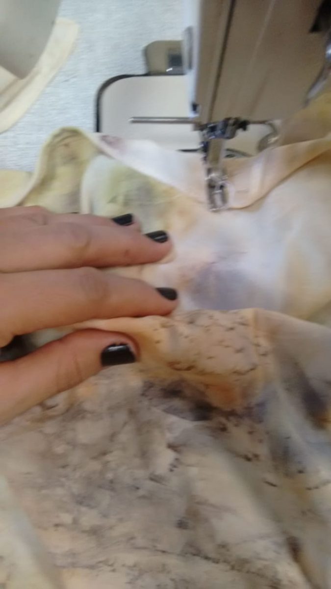 Imagem de mão feminina durante trabalho na máquina de costura