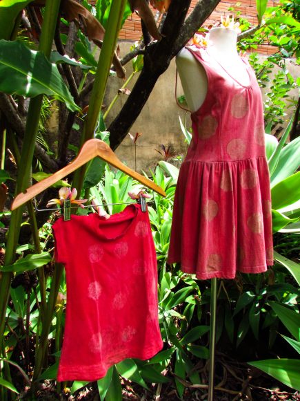 Vestidos adulto e infantil pendurados na árvore.