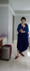 Editora de Histori-se vestindo macacão marca Arabescko azul e casaco.